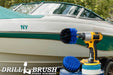 The Medium Blue Drillbrush 4O Marine & Pool Kit with two 4 inch Variety Pads with an Original in a cordless drill on a bucket in front of a boat on a trailer.