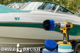 The Medium Blue Drillbrush 4O Marine & Pool Kit with two 4 inch Variety Pads with an Original in a cordless drill on a bucket in front of a boat on a trailer.