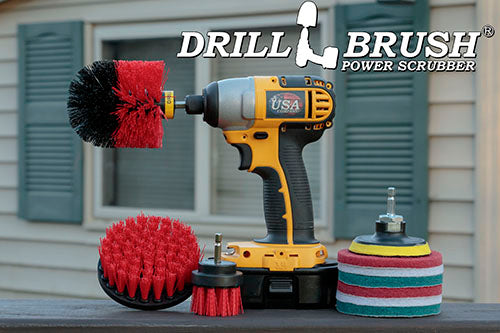 The Stiff Red Drillbrush 42O Outdoor & Patio Kit with six 4 inch Variety Pads with an Original in a cordless drill on a wooden railing on a deck in front of window.