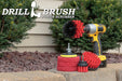 The Stiff Red Drillbrush 42O Outdoor & Patio Kit with three 4 inch Moderate Red Pads with an Original in a cordless drill on a brick planter in front of some shrubs and a rock garden.