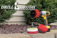 The Stiff Red Drillbrush 4O Outdoor & Patio Kit with two 4 inch Variety Pads with an Original in a cordless drill on a brick planter in front of some shrubs and a rock garden.