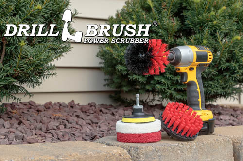 The Stiff Red Drillbrush 4O Outdoor & Patio Kit with two 4 inch Variety Pads with an Original in a cordless drill on a brick planter in front of some shrubs and a rock garden.