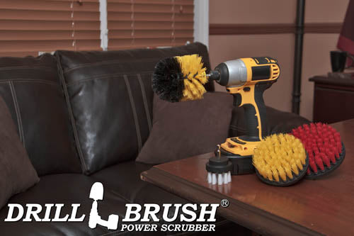 The Drillbrush 542O Variety Brush Kit in a cordless drill sitting on a wooden desk in front of a leather sofa.