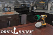 The Drillbrush Medium Green Original and Soft White 5 inch Variety Brush Kit on a table in front of kitchen counters, a stove, a microwave, and other appliances.
