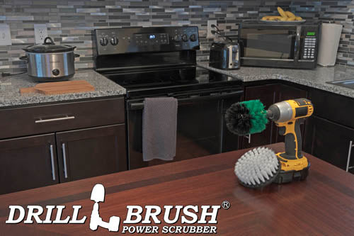 The Drillbrush Medium Green Original and Soft White 5 inch Variety Brush Kit on a table in front of kitchen counters, a stove, a microwave, and other appliances.