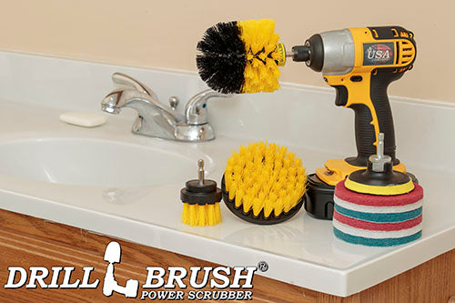 The Medium Yellow Drillbrush 42O Bathroom Kit with six Variety Pads with an Original in a cordless drill on a bathroom counter in front of a sink.