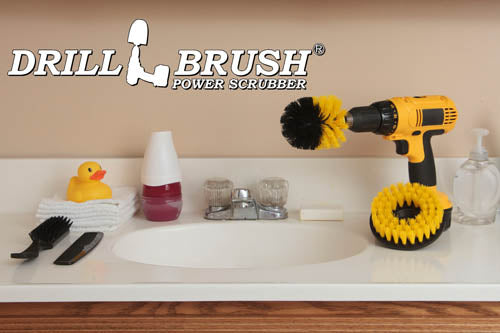 The Drillbrush 5H-OS Medium Yellow Bathroom Brush Kit on a bathroom counter next to a sink surrounded by toiletries.
