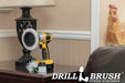The Drillbrush EMS-2L Soft White Home & Auto Brush Kit in a cordless drill sitting on an end table next to a leather sofa in front of a lamp.