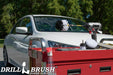 The Drillbrush 42O-5X Soft White Home & Auto Brush Kit in a cordless drill sitting on a tool cart in front of a white sedan.
