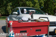 The Drillbrush 52O Soft White Home & Auto Brush Kit in a cordless drill sitting on a tool cart in front of a white sedan.