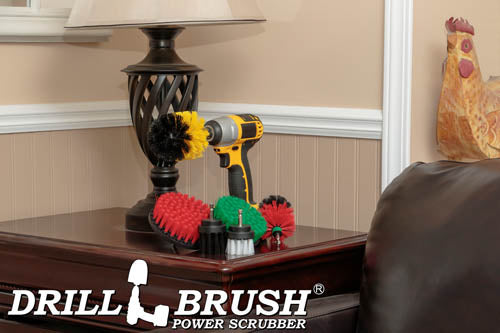 The Drillbrush 542OMS-2L Variety Brush Kit in a cordless drill sitting on a wooden end table next to a leather sofa in front of a lamp.
