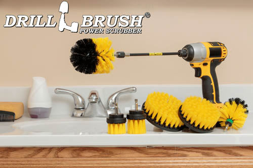 The Drillbrush 542OMS-2L-7X Medium Yellow Bathroom Brush Kit in a cordless drill sitting on a bathroom counter next to a sink and toiletries.
