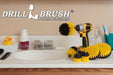 The Drillbrush 542OMS-2L Medium Yellow Bathroom Brush Kit in a cordless drill sitting on a bathroom counter next to a sink and toiletries.