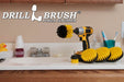 The Drillbrush 5542O Medium Yellow Bathroom Brush Kit in a cordless drill sitting on a bathroom counter next to a sink and toiletries.