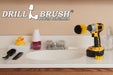 The Drillbrush 2M Medium Yellow Bathroom Brush Kit in a cordless drill sitting on a bathroom counter next to a sink and toiletries.