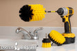 The Drillbrush 42J-5X Medium Yellow Bathroom Brush Kit in a cordless drill sitting on a bathroom counter next to a sink.
