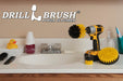 The Drillbrush 52O Medium Yellow Bathroom Brush Kit in a cordless drill sitting on a bathroom counter next to a sink and toiletries.
