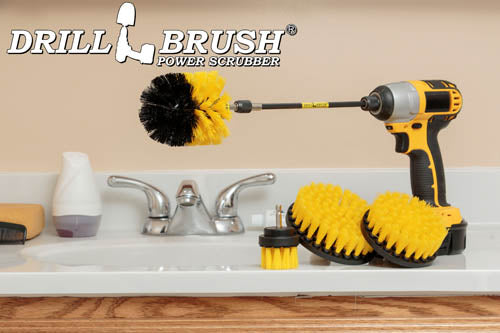 The Drillbrush 542O-7X Medium Yellow Bathroom Brush Kit in a cordless drill sitting on a bathroom counter next to a sink and toiletries.
