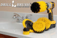 The Drillbrush E542J Medium Yellow Bathroom Brush Kit in a cordless drill sitting on a bathroom counter next to a sink.